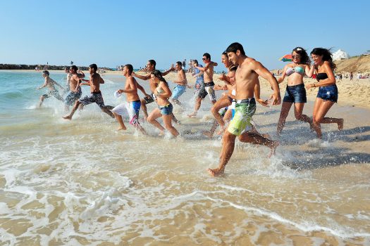 ASHKELON,ISR - JUNE 06:Israeli high school graduates runs to the sea on June 20 2011.According to the OECD The percentage of high school graduates in Israel is among the highest in the world, about 92%